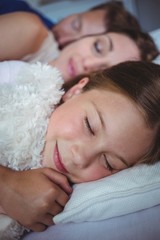 Family sleeping on bed