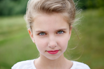 Portrait of a beautiful young girl lying on the grass