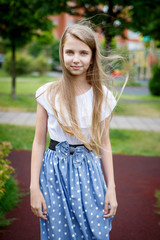 Naklejka premium Portrait of a beautiful young girl in the Park skirt blouse nature fashion style