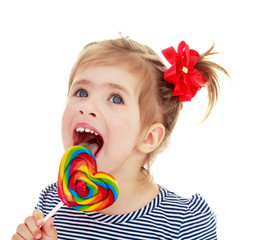 Girl licks candy on a stick