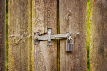 Wooden gate with hinge and padlock