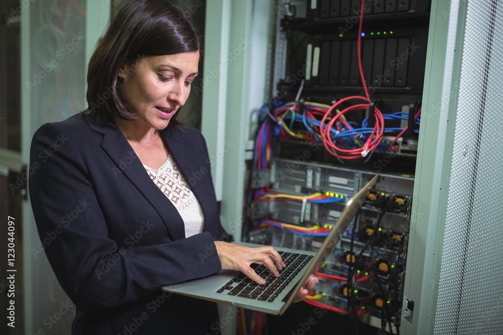 Aufkleber Technician using laptop while analyzing server