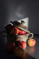 Fresh apples in pot of clay in shadow of sun
