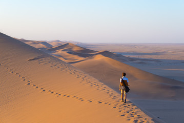 Tourist walking on the scenic dunes of Sossusvlei, Namib desert, Namib Naukluft National Park,...