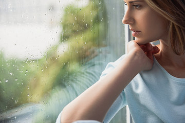 beautiful lonely woman sitting in front of window