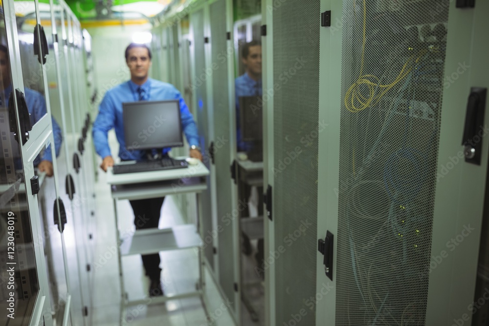 Poster Technician walking with personal computer in hallway