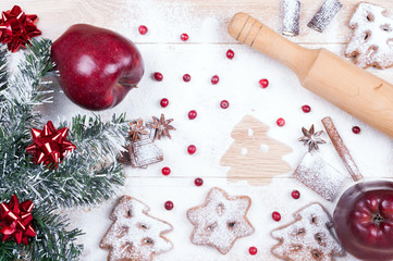 Cooking cookies. Flour, chocolate, cranberries, apples, spices, rolling pin on a wooden background. Christmas background. Top view