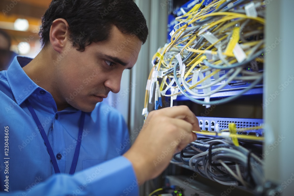 Poster technician checking cables in a rack mounted server