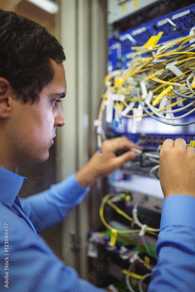 Poster technician checking cables in a rack mounted server