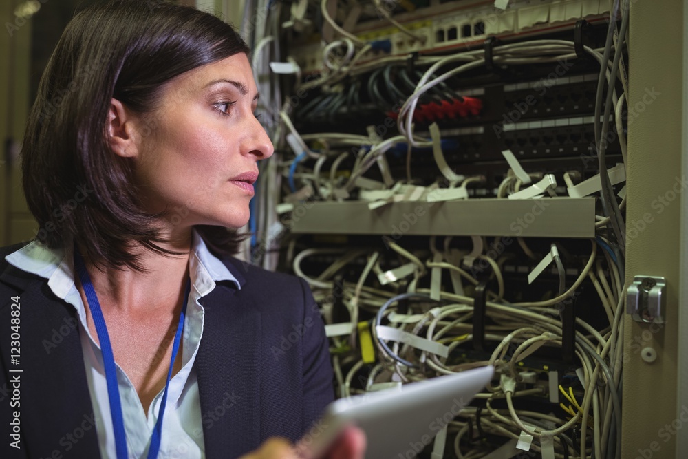 Aufkleber Technician using digital tablet while analyzing server