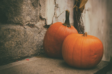 Halloween autumn holiday decoration at the stone stairs. Red pumpkins against grunge wall, seasonal...