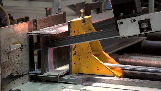 Automatic Band Saw Machine is sawing a metal I-beam.