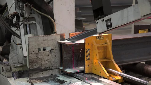 Automatic Band Saw Machine is sawing a metal I-beam.