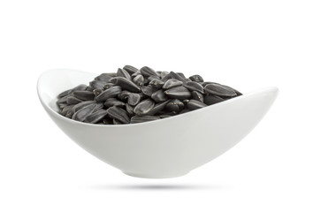 Sunflower seeds in bowl isolated on white background