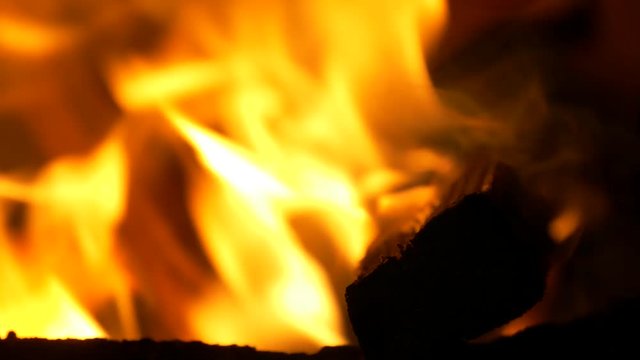 Big closeup of burning wood tended with axe