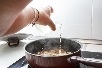 Mamá preparando en casa unas chuletas con salsa de cebolla caramelizada.