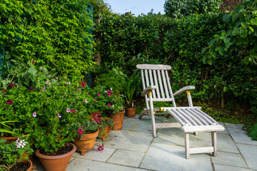 A wooden garden recliner in a quiet spot in an English country garden