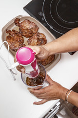 Mamá preparando en casa unas chuletas con salsa de cebolla caramelizada.