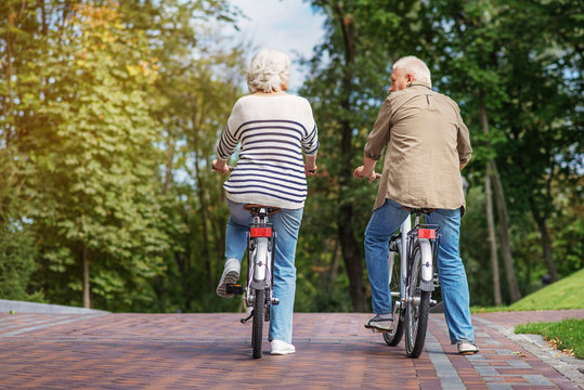 Mature man and woman cycling in nature