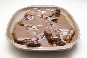 Mamá preparando en casa unas chuletas con salsa de cebolla caramelizada.