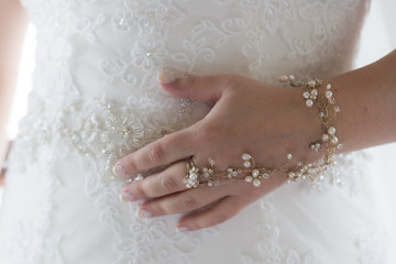 Hand of bride with a manicure hand and bracelet on the backgroun