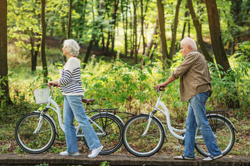 Obraz premium Mature husband and wife riding bikes in nature
