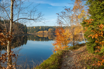 Spiegelungen der Herbstf&auml;rbung im blauen Wasser am Frankenteich im S&uuml;dharz