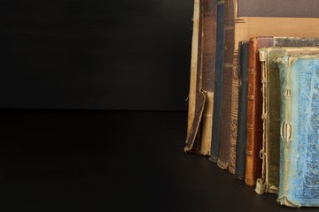 Stack of old books, copyspace for your text. Antique books on old wooden shelf. 
