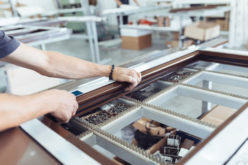 Manual worker assembling PVC doors and windows. Manufacturing jobs. Selective focus. Factory for...