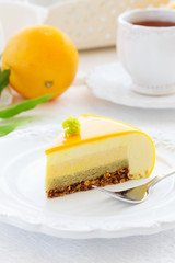 Cake with orange mousse and almond krokantom in the mirror glaze. Selective focus.