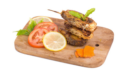 Fried fish in a plate with ingredients