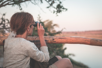 Tourist watching wildlife by binocular on Chobe River, Namibia Botswana border, Africa. Chobe...