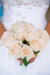 Beautiful bride with pink roses bouquet. Close up of pink roses bouquet held by a bride