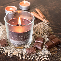  Scented decorative candles.   Scented decorative candles, chocolate bar and cinnamon sticks on...