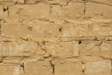 Old worn yellow brick wall background.