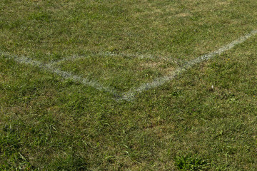 Football soccer field corner with white marks, green grass.