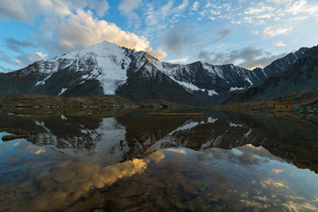Obraz na płótnie Canvas Reflection of clouds on sunset in the mountainous lake. Valley of seven lakes, Gorny Altai, Russia.