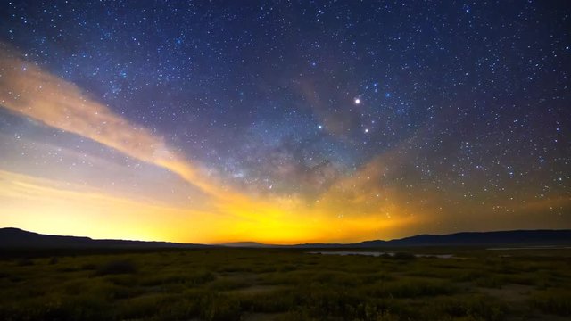 Astrophotography time lapse with pan right motion of Milky Way galaxy rising over Desert Gold wildflower super bloom 2016 in Carrizo Plain National Monument, California