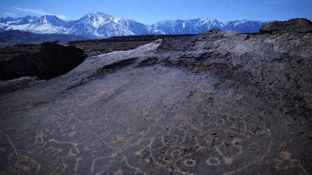 Astrophotography time lapse of moonset over Native American petroglyphs in Eastern Sierra, California