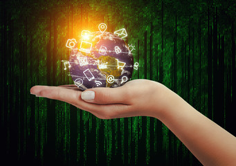 hand holding globe and media icons flying in front of matrix background