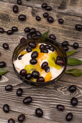 ice cream with slice of orange, black grapes and kiwi on wooden background