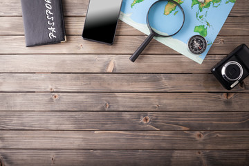 Preparation for Traveling concept, passport, smartphone, camera, map on a wooden background.