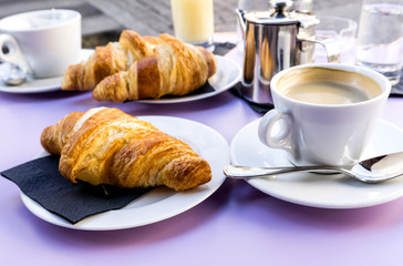 Breakfast with coffee and croissants on table