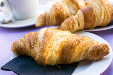 Breakfast with coffee and croissants on table