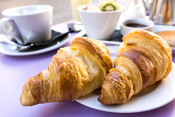 Breakfast with coffee and croissants on table