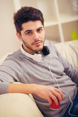 Portrait of a handsome young man with headset and cup of coffee