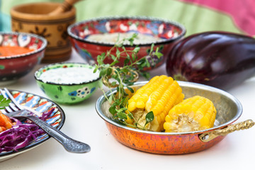 Corn elotes in copper pan. Mediterranian meze.