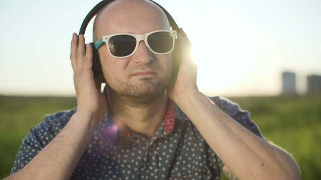 Man putting on headphones and listening to music