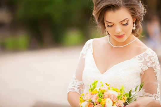 Young bride in wedding dress holding bouquet, portrait