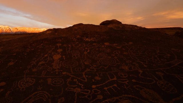 Time lapse with zoom out motion of morning glow over Native American Petroglyphs in Eastern Sierra, California